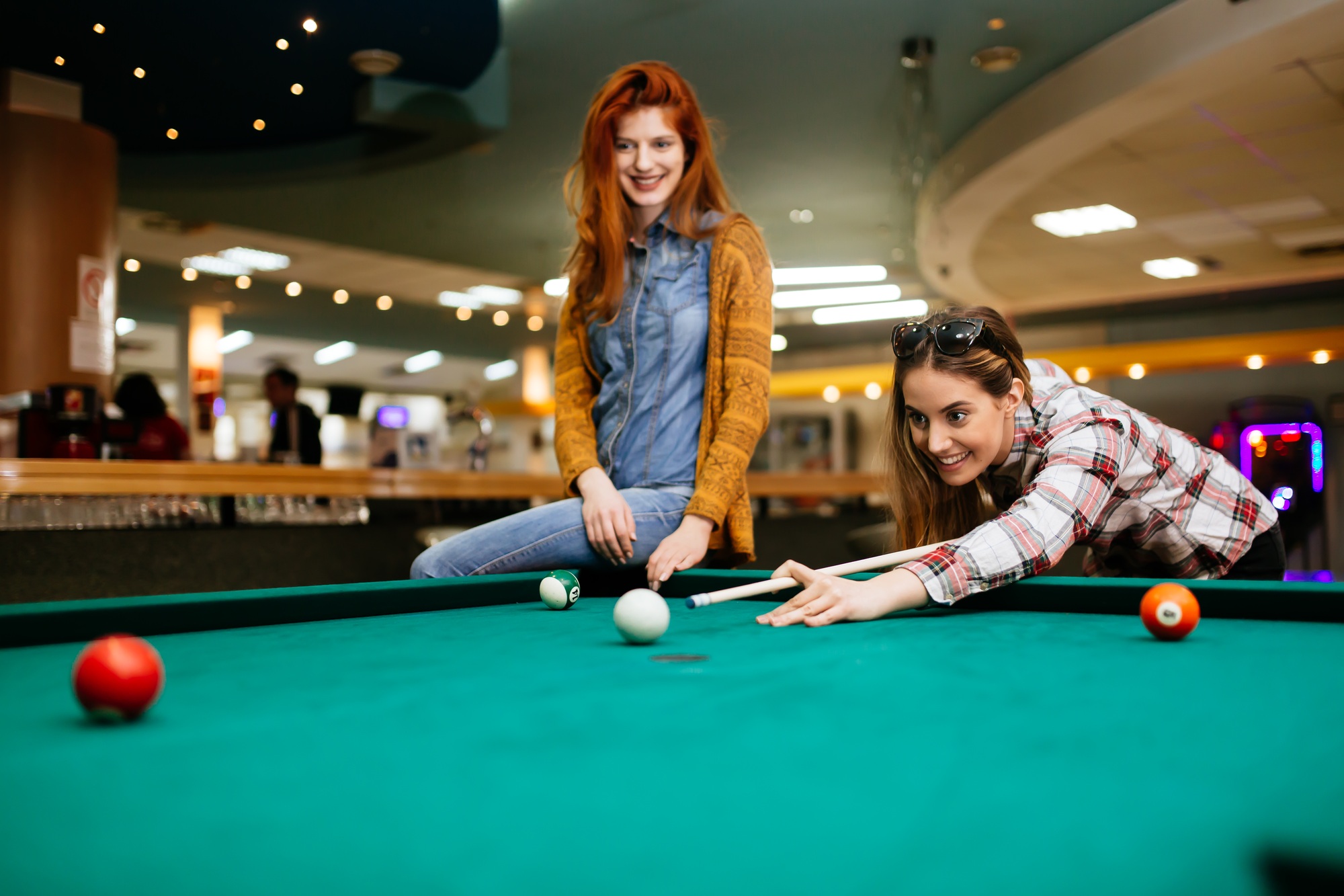 Beautiful women playing billiards